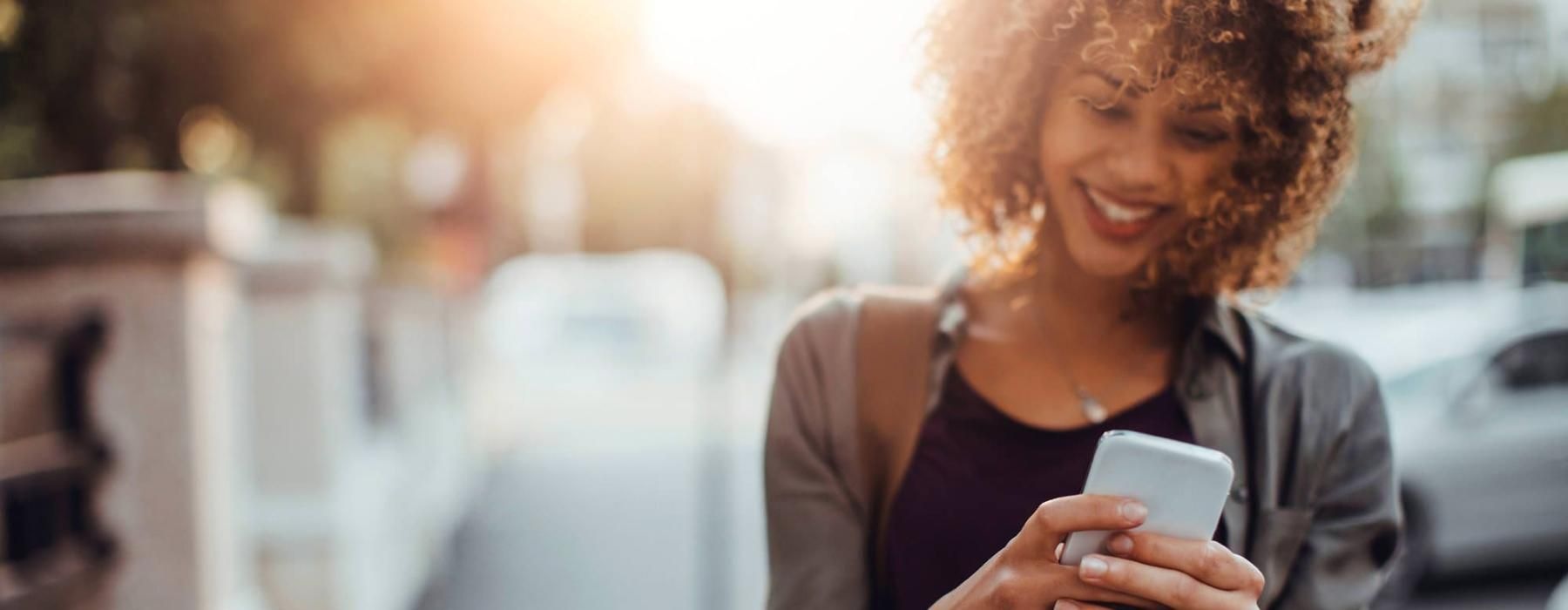 Find your perfect fit at The Jax woman texts on her phone as she walks through the city