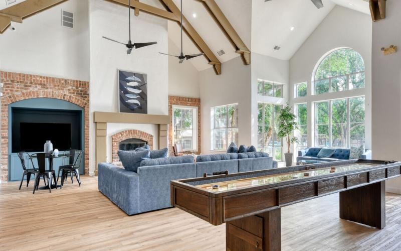 Take advantage of all The Jax has to offer a large room with a fireplace and a large couch and windows and a game table