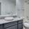 a bathroom with a marble countertop a sink a toilet and a tub