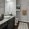 a bathroom with a marble countertop a sink a toilet and a shower