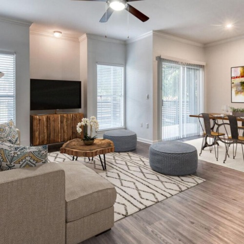 Find your perfect fit at The Jax a living room with a wood floor a couch and a dining table