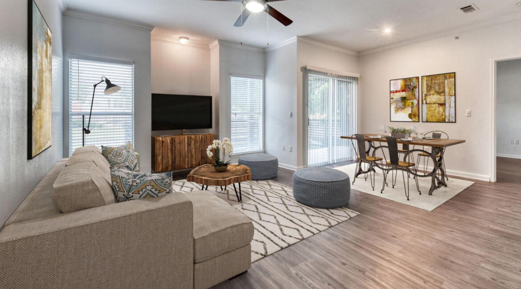Find your perfect fit at The Jax a living room with a wood floor a couch and a dining table