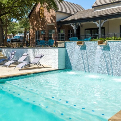 Relax and unwind poolside a swimming pool in front of a building